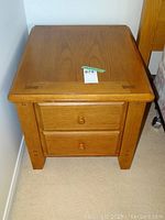 View of the night table showing the top surface, two drawers, and front legs.