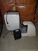 Garrison dehumidifier, Honeywell humidifier, and Classic heater grouped on concrete floor against wall