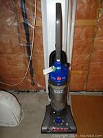 Full front view of Hoover WindTunnel upright vacuum showing handle, blue motor cover, and dustbin canister.