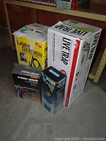 Photo showing all the boxed items: Chaplin lawn and garden sprayer, live animal trap, propane torch kit, and glue gun in their packaging.