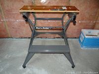 Front view of Black & Decker Workmate with wooden top and metal frame showing branding and condition.