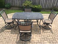 Full set on brick patio showing table and four swivel chairs around it