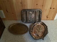 Three silver plate serving trays, two meat trays with branch embossing, one Birks Ellis Regency plate footed rectangular tray, shows heavy use and tarnish.
