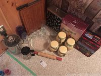 Overview photo showing the tall Corlini pot with glass lid, assorted drinking glasses, wooden rolling pin, ceramic canisters, wooden cutting board, and cookie tins.