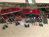 Full setup showing two original Santa’s Workshop boxes at the back, six porcelain houses, miniature characters and pine tree accessories arranged on carpet.