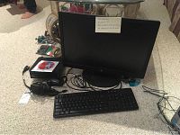 Complete Lenovo desktop setup showing monitor, keyboard, mouse, tower, and cables on carpeted floor.