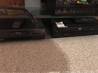 Toshiba VHS VCR with remote and Pioneer DVD player side by side on carpeted floor