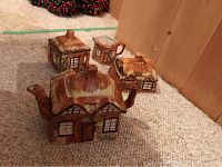 Photo showing the full view of the cottageware ceramic tea set including teapot, sugar bowl, creamer, and butter dish lid arranged on carpet.