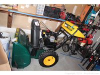 Full side view of snowblower in garage showing overall condition, size and attachments