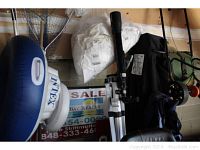 Full view of Polaris by Meade telescope on tripod next to a blue inflatable ring and other garage items.