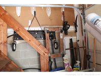 Thatcher attachment hung on garage wall next to garden tools and other equipment