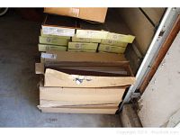 Boxes of wood look ceramic tiles stacked in a garage corner.