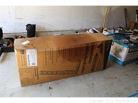 Full view of cardboard box containing Werner SpaceMaster folding wood attic ladder, showing overall condition and size.