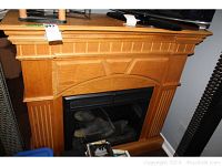 Full view of the laminate electric fireplace heater with wood finish surround and detailed molding.
