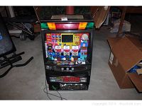 Front view of the slot machine showing chibi form style graphics, three reels with symbols, buttons, and coin slot.