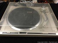Front view of vintage Pioneer PL-300 turntable with closed clear dust cover, showing black rubber platter and tonearm tucked in.