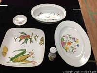 All pieces laid flat showing entire serving set including fruit and floral patterns on white porcelain with gold rims