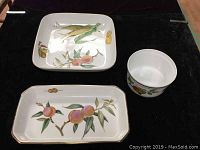 Three Royal Worcester Evesham porcelain serving pieces including square serving bowl, rectangular serving bowl, and round quiche bowl displayed on dark surface.
