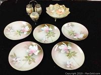 Photo of RS Germany porcelain set including footed bowl, 5 dessert plates, and cruet set on a black background