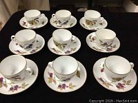 Nine vintage Royal Worcester Evesham cups and saucers displayed with fruit and leaf decorated white porcelain and gold trim.