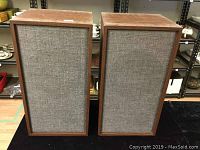 Pair of vintage Telefunken stereo speakers showing front fabric grilles and rectangular wood cabinets.