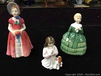 Overview of three Royal Doulton figurines Diana, Belle, Innocent showing their size and posture