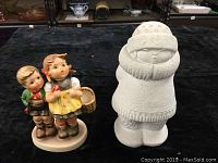 Two vintage collectible figurines including Hummel 'To Market' and Belgium Eskimo stone art figurine