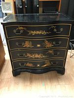 Front view showing 4 curved drawers with hand-painted Asian landscape motifs and ornate metal handles.