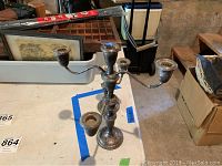 Full view of one of the sterling silver candlestick holders with multiple arms seen on a table.