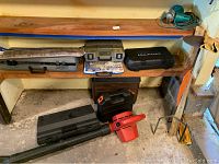 Photo showing three tool boxes on a wooden and metal shelf, a set of Dremel rotary tool bits, and a Torro 550 TBX leaf blower on the floor in front.