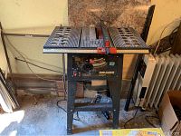 Front view of Task Force 10-inch table saw on stand showing tabletop, blade, and base frame.