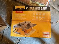 Top view of the wet saw box showing the model Workforce THD550 7 inch tile wet saw with image of the saw and key features including cutting up to 1-3/8 inch thick tile.