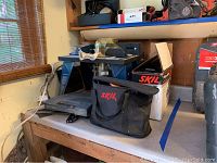 Workbench with Ryobi R163 router, Skil box, and Skil bag.