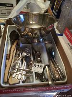 Overall view of lot including silverplate bowl, dish, and assorted flatware arranged on a tray.