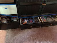 Wide angle view showing three drawers open filled with CDs and DVDs, with visible covers and album art.