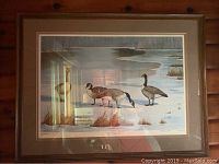 Front view of framed print showing Canadian geese in winter landscape with snow and grass.