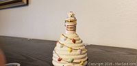 Front view of Lenox Honey Bell ceramic honey jar with bear figurine lid and honey drip decorations.