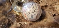 Side view of the signed baseball showing legible signatures including Ron Taylor and the year 1970.