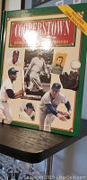 Cover photo of Cooperstown baseball book showing various baseball players and indication of included 1985 collector's cards.