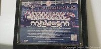 Framed 2000 New York Yankees World Series Champions plaque with team photo and text listing players and staff.