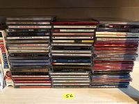 Photo of stacked CDs showing various artists and titles including Bob Dylan, Garth Brooks, Janis Joplin, Susan Boyle, and Sting.