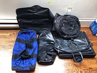 Overview photo showing all six pieces of luggage grouped together on the floor against a wall, illustrating size and color variety