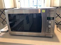 Full view of the Panasonic NN-C994S convection microwave oven on counter showing stainless steel exterior and digital panel.