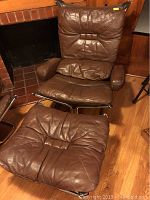 Full view of brown leather chair with matching ottoman on chrome cantilever frame