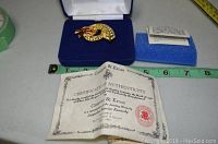 Brooch in open blue velvet-lined box with blue insert and Certificate of Authenticity in front.