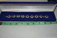 Camrose & Kross bracelet in original box, placed next to a measuring tape showing about 8 inch length.