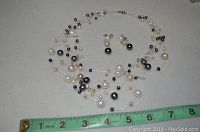 Full view of necklace and earrings together with ruler showing necklace length.