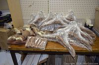 Multiple brown velvet hangers of different sizes and shapes, some still in plastic packaging, displayed on wooden surface.