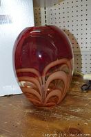 Front view of red and amber vase showing swirling pattern
