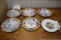 Photo showing six collector plates with floral and bird designs and one with pink roses; includes certificate